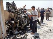 Iraqis view the wreckage of a mini- van that was thrown onto a
rooftop next to the Jordanian Embassy in a bomb explosion in
Baghdad, Iraq. A massive car bomb exploded outside the embassy
Thursday morning, reportedly killing 11 people and wounding many
more.