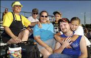 From left, Deborah Flint, Ed Flint, Billie Weeks, Logan Weeks,
Vernon Weeks and Corina Weeks, all of Lawrence, await the start of
the demolition derby at the Douglas County 4-H Fairgrounds. They
attended the derby Aug. 1 to cheer on friends who were driving in
the contest.