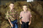 Preston Randall, 10, a member of Meadowlark 4-H Club, left, and
Simon Fangman, 9, a member of Clinton Eagles 4-H Club, wait for the
start of the livestock auction at the Douglas County Free Fair.
Randall was selling a steer and Fangman was selling a sheep Sunday
during the auction.
