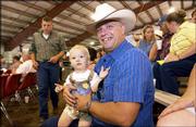 Douglas Berg, Lawrence, enjoys some time with his 1-year-old
nephew, Reid Plinsky, while attending the livestock auction of the
Douglas County Free Fair. "He&squot;s a future 4-H&squot;er," Berg said Sunday.