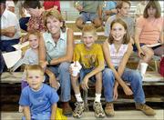 Stacy Burkhart, Baldwin, center, and her children attend the
livestock auction at the Douglas County Free Fair. From left are
Garrett, 5; Hayden, 4; Stacy; Hunter, 9, and Ramie, 10. Ramie sold
her reserve champion meat goat during Sunday's auction.