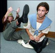 Marrianne Schroer, left, ties her right shoe as Sommer Brecheisen
helps her with the left one. Schroer and Brecheisen prepared for a
dress rehearsal of "Women of the Wind" on Tuesday at Baker
University. The play, written and directed by Lori Lee Triplett of
Baldwin, will premiere Tuesday, the final production in Heart of
America Performing Arts' summer season.