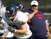 Safety Zach Dyer, left, breaks toward the ball carrier as Kansas
University football coach Mark Mangino watches. Dyer, a senior
co-captain and former quarterback, is competing to be the Jayhawks'
starting strong safety this fall.