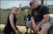 Jeff and Addie Cullen, Tonganoxie, accompany their son Adrian, 2,
to Kids Day with the Kansas University football players. The event
was Sunday at the football practice fields.