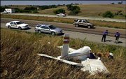 Bobby Warren, left, and Bill Davis, Federal Aviation Administration
safety inspectors from Wichita, take photos and examine a aircraft
crash site just off U.S. Highway 81 south of Concordia. The pilot,
David Kadel, 54 of Randall, survived the crash and was air-lifted
to Wichita for treatment of his injuries, the Kansas Highway Patrol
said. No one else was in the plane. Lt. John Eichkorn said the
single-engine experimental plane apparently crashed onto U.S. 81
near Concordia Municipal Airport, then slid off the highway. A
tractor-trailer had to swerve to avoid the aircraft as it hit the
road, but there was no collision, Eichkorn said. The Federal
Aviation Administration was investigating.