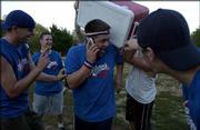 Caleb Skulskie, center, captain of Wattleneck, is doused with water
from an ice chest after his team defeated Rudy's Pizzeria 9-8 in
the Kaw Valley Kickball League's championship game. Celebrating
Sunday in South Park are, from left, teammates Seth Martin,
Jonathon Thompson, Skulskie and Noah Martin. Nolan Washatka, a
member of The Pig team, is dumping the water. Skulskie was on the
phone to a former teammate in Alabama.