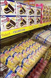 Twinkies await sale on a shelf in a Wonder Bread Outlet store in
Lawrence. More than 70 years after the debut of the world famous
Hostess Twinkie, the current baker of the treats is struggling as
competitors, including Krispy Kreme Doughnuts, Inc. eat away at the
baked goods industry profits.