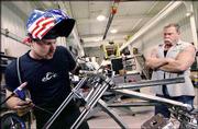 Paul Teutul Jr., left, works on a new chopper under the watchful
eye of Paul Sr., in this scene from Discovery's "American Chopper,"
in this undated publicity photo. The show airs at 9 p.m. Mondays.