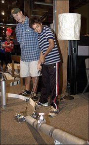 Staff members at Callahan Creek, 805 N.H., kick off their United
Way Campaign by inviting Boys and Girls Club of Lawrence members to
take part in a miniature golf experience. At Wednesday's event,
staff member J. Chambers, left, helps Brian Moeding, 13, a Central
Junior High School student, get through a series of pipes to the
final hole.