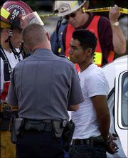The suspect Court records in Jackson County, Mo., show Nam Ouk Cho,
19, of Lee's Summit, Mo., was arrested twice in 2001 while still a
juvenile. Cho, pictured above Tuesday, and a friend are accused of
breaking into several cars outside a Lee's Summit apartment complex
in May 2001.