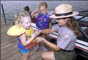 Bunnie Watkins, natural resources management specialist at Perry
Lake, helps Hailey Engelke, 3, left, and Morgan Kubick, 3, both of
Perry, during a water safety demonstration. Recreation officials
stressed safety Thursday before the long Labor Day weekend.
