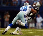 Dallas' Darren Woodson (28) hits Oakland wide receiver Marcus
Knight. The Cowboys beat the Raiders, 52-13, Thursday in Irving,
Texas.