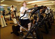 Ellen Lipschitz, foreground, a scientist at Hoffmann-La Roche
pharmaceutical company, works out on an elliptical trainer at the
company fitness center in Nutley, N.J. Lipschitz has lost 93 pounds
and lowered her blood pressure through exercise.