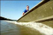 Rob Catloth, head coach for Kansas University's rowing team,
navigates the Kansas River during a practice. Because the Kansas
River has been so low at times, the rowing team has been confined
to less than 3 miles of navigable water. Recent rains, however,
have increased the river's level in this area. Across the state,
rivers are at their lowest levels in a decade. Catloth raced across
the water Friday.