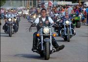 Motorcyclists ride along 20th Avenue on the Kansas State Fairgrounds as part of the annual Motorcycle Rally Parade in Hutchinson.