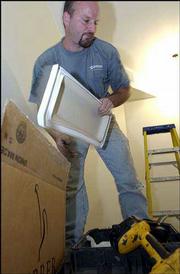 Ranter, a plumber with Chaney Inc. installs bathroom fixtures
Wednesday in a downtown Lawrence business.