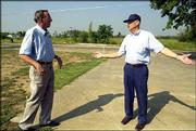 John Houck, left, and Hank Pichler discuss plans to rebuild a civic
center and post office in Franklin. The men last week talked about
the post office, which once stood where the flag in the background
flies. It was destroyed by a tornado that struck the small
southeast Kansas town May 4.