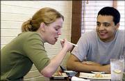 Beth Waite, a May graduate of Kansas University, and Carlos Casas,
KU senior, enjoy a spicy tuna roll and a California Roll during
their second visit to Sushi Station. Casas says he loves sushi, but
hasn't convinced Waite to try raw fish. She still prefers cooked or
vegetarian sushi.