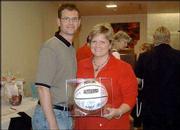 Stephen and Susie Wilson receive a basketball that was signed by
the 2003-2004 Kansas University men's team after submitting the
highest bid in a live auction at Lawrence Presbyterian Manor. The
auction was Sept. 16 and was part of the manor's Soup and Pie
Supper and Auction. The fund-raiser benefited the manor's Good
Samaritan program.
