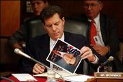 U.S. Sen. Sam Brownback, R-Kan., autographs pictures of himself
during a Senate Appropriations hearing on the budget for the war in
Iraq. The Sept. 22 hearing featured testimony by Paul Bremer, the
American civilian administrator of Iraq.