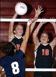 Lawrence High's Carolyn Raynes, left, and Elise McDonald block a
kill attempt from Olathe East's Lindsey Gray. LHS defeated Free
State, 2-0 (28-26, 25-22), but lost to Olathe East and Roeland Park
Miege Thursday night at LHS.