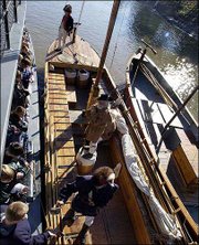 Members of the Discovery Expedition of St. Charles, Mo., speak to
students from a keelboat docked next to a barge in Covington, Ky.
The men are official re-enactors of the national 2003-2006 Lewis
& Clark bicentennial commemoration and will retrace the entire
waterway portion of the original 1803-1806 expedition. The keelboat
is 55 feet long, and the pirogue docked to the right is 39 feet
long.