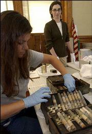 Kathy Richardson, a hazardous waste technician with the Lawrence
Waste Reduction and Recycling Division, left, inspects an old
doctor's bag from the collection of the Watkins Community Museum of
History with museum director Rebecca Phipps. Employees at the
museum recently opened the medicine bag and discovered a vial of
nitroglycerin, used for certain heart ailments but also used in
making dynamite.