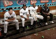 Florida Marlins players, from left, Josh Beckett, Gerald Williams
and Juan Pierre, sit in the dugout during a rain delay. After
enduring a 39-minute wait, the Yankees' bats came to life and they
pulled away for a 6-1 victory in Game 3 of the World Series Tuesday
in Miami.