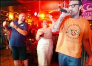 Sean McKean, right, sings "The Humpty Dance" in front of a crowd
gathered at Old Chicago on karaoke night. The bar and grill has
since discontinued a regular karaoke night.