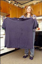 Christina Neavitt, of Lecompton, holds a shirt she wore before she
went on the Atkins Diet and lost 107 pounds in 14 months. Neavitt
said the diet has helped improve her overall health.