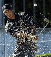 Tiger Woods blasts out of a bunker on the ninth hole during a
practice round. Woods practiced Wednesday for the Tour
Championship, which begins today at Champions Golf Club in Houston.