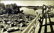 People stand on the southbound span of the Kansas River Bridge to
observe the makeshift village "Tent City" during the filming of the
movie "The Day After" in September of 1982.