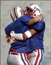 Olathe North's Codi Willard, left, embraces teammate Kellen Long
after the Eagles beat Hutchinson, 28-13, in the Class 6A state
championship game. O-North won its seventh title in eight years
Saturday at Memorial Stadium.