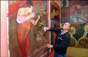 Cuban-born artist Fito Garche wipes off some of his artwork while
setting up his most recent exhibition, "Memories of Havana," at The
Red Dresser, 624 N. Second St. The show will remain on view through
December.
