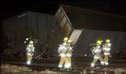 Lawrence-Douglas County Fire & Medical firefighters inspect the
wreckage of a Union Pacific train's coal cars. Sixteen cars
derailed Wednesday evening on the tracks in North Lawrence. No
injuries were reported. Crews worked through the night to clean up
the coal and wreckage.
