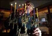 Herb Friedson, a member of the Lawrence Jewish Community Center,
lights the menorah, which is used during the celebration of
Hanukkah. Eight candles represent the eight days of Hanukkah.