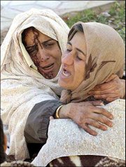 Grieving, injured Iranian women embrace after an earthquake in the
Iranian city of Bam, 630 miles southeast of Tehran. The death toll
from Friday's quake was at least 5,000.
