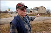 Ted Boyle, a North Lawrence resident and president of the North
Lawrence Improvement Assn., points out some new raised houses being
constructed that have been built up to flood insurance standards
but that push water into low-lying areas where older homes are
located. Boyle says flooding is the No. 1 concern of his neighbors.