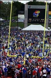 KU football fans climb the north goalpost after KU's win over
Missouri in September at Memorial Stadium. Fans ripped down both
goalposts before taking them to rest at Potter Lake on campus.
