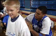 Kansas University basketball player Wayne Simien signs an autograph
for Harry Brewer, 10, of Gladstone, Mo., during the team's Holiday
Basketball Clinic at Allen Fieldhouse. Youngsters got a chance to
learn from KU players and coaches during the Dec. 27 clinic.
