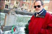 Jeff Jerome, curator at the Poe House and Museum in Baltimore,
stands near author Edgar Allan Poe's grave in Baltimore. This
year's traditional offering of roses and cognac on the anniversary
of Poe's birth was accompanied by a note taking a jab at the
French.