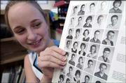 Holly Maygers, a ninth-grader at West Junior High School, displays
a page of student school portraits from an early-1960s yearbook.
The West yearbook staff is selling surplus Warhawk yearbooks dating
from 1961 to 2003 to raise money.