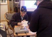 Lawrence author Tom Mach signs copies of his first novel, "Sissy!"
at Framewoods Gallery in Topeka. The book blends historical fact
and fiction to tell the story of a young Lawrence woman who
disguises herself as a man to fight for the Union army during the
Civil War.