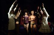 Frank-N-Furter (Scott Cox), center left, and Rocky (Brian Shortess)
make their way down the aisle in "The Rocky Horror Show." The stage
version comes to Lawrence this weekend.