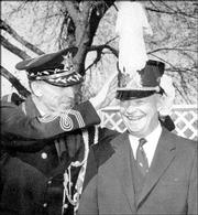 Russell Wiley, director of the Kansas University bands from 1934 to
1971, designates a President Dwight Eisenhower an honorary band
member in this 1955 Jayhawker Yearbook photo. Wiley's long tenure
as director has helped the marching band program maintain stability
and tradition through the years.