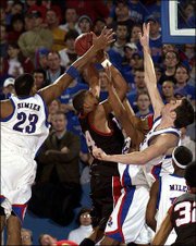 Wayne Simien (23), J.R. Giddens and David Padgett, right, converge
on Texas Tech's Andre Emmett. Despite the attention, Emmett
finished with a game-high 29 points.
