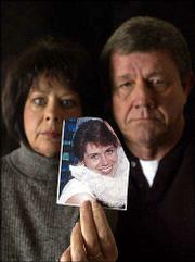 Marilyn and Gary Anderson, Lawrence, hold a picture of their
missing daughter, Lesley Smith, 38, who has been missing since Jan.
27. Police don't know how much danger she might be in.