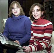 Tiffany Muller, right, and Erin Norris hold their wedding album at
home in Topeka. The idea that Muller and Norris, or other same-sex
couples could marry legally someday has legislators considering a
proposed constitutional amendment to reinforce Kansas'
long-standing policy against recognizing such unions.
