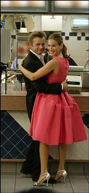 Carrie (Sarah Jessica Parker) and Aleksandr (Mikhail Baryshnikov)
are shown in an episode from the sixth season of "Sex and the City"
in which Aleksandr surprises Carrie with an Oscar de la Renta
dress.