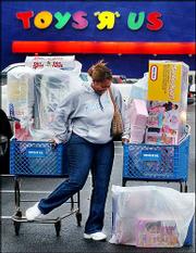 Carolyn Hardy struggles to maintain two shopping carts filled with
toys at Toys "R" Us in Birmingham, Ala., in this Nov. 28 photo.
After the brutal price wars that claimed two toy store chain
casualties this past holiday season, toymakers say they&squot;re standing
up to some of the discount retailers, particularly Wal-Mart Stores
Inc., to protect themselves and the industry.
